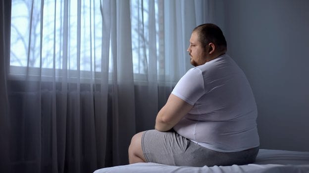 فردی چاق و افسرده در اتاق خواب